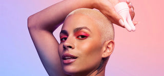 Person with buzzcut and pink eyeshadow holding VUSH Swish dual-tip vibrator