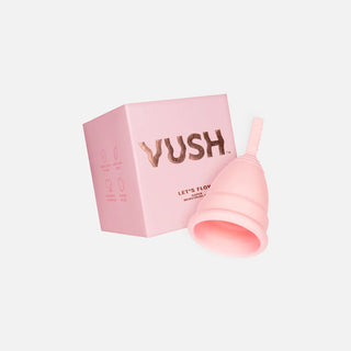 Pink square box that reads "VUSH LET'S FLOW SUPER MENSTRUAL CUP" next to upside down pink menstrual cup against light grey background